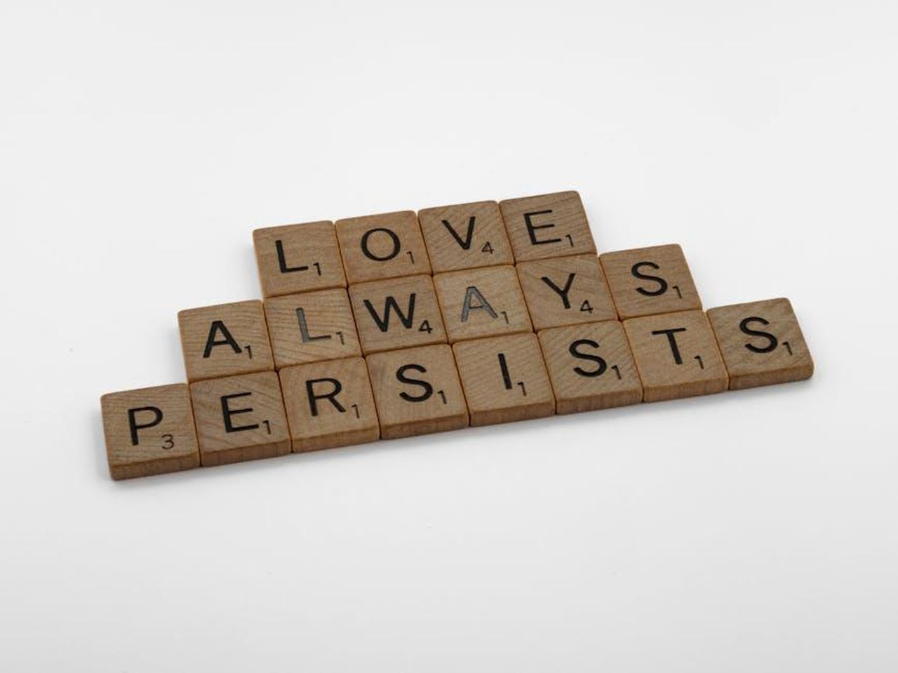 Cosa_sono_le_5_lingue_dellamore_mGV05uWt1X - Confidenze24 Source: Brett Jordan - pexels - Scrabble tiles on a white background form the phrase 'Love Always Persists', emphasizing a message of enduring love.