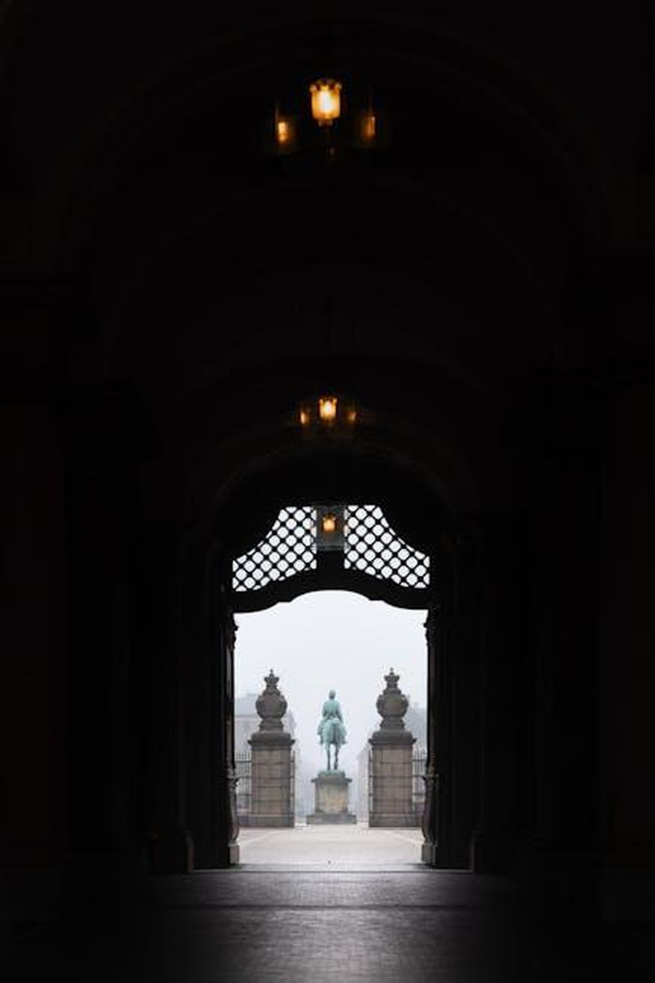 Critiche_alla_monetizzazione_del_titolo_reale_LeDsUp7VIJ - Confidenze24 Source: Ryan Klaus - pexels - Moody silhouette of the Frederiksstaden Arch leading to a statue in Copenhagen, Denmark.