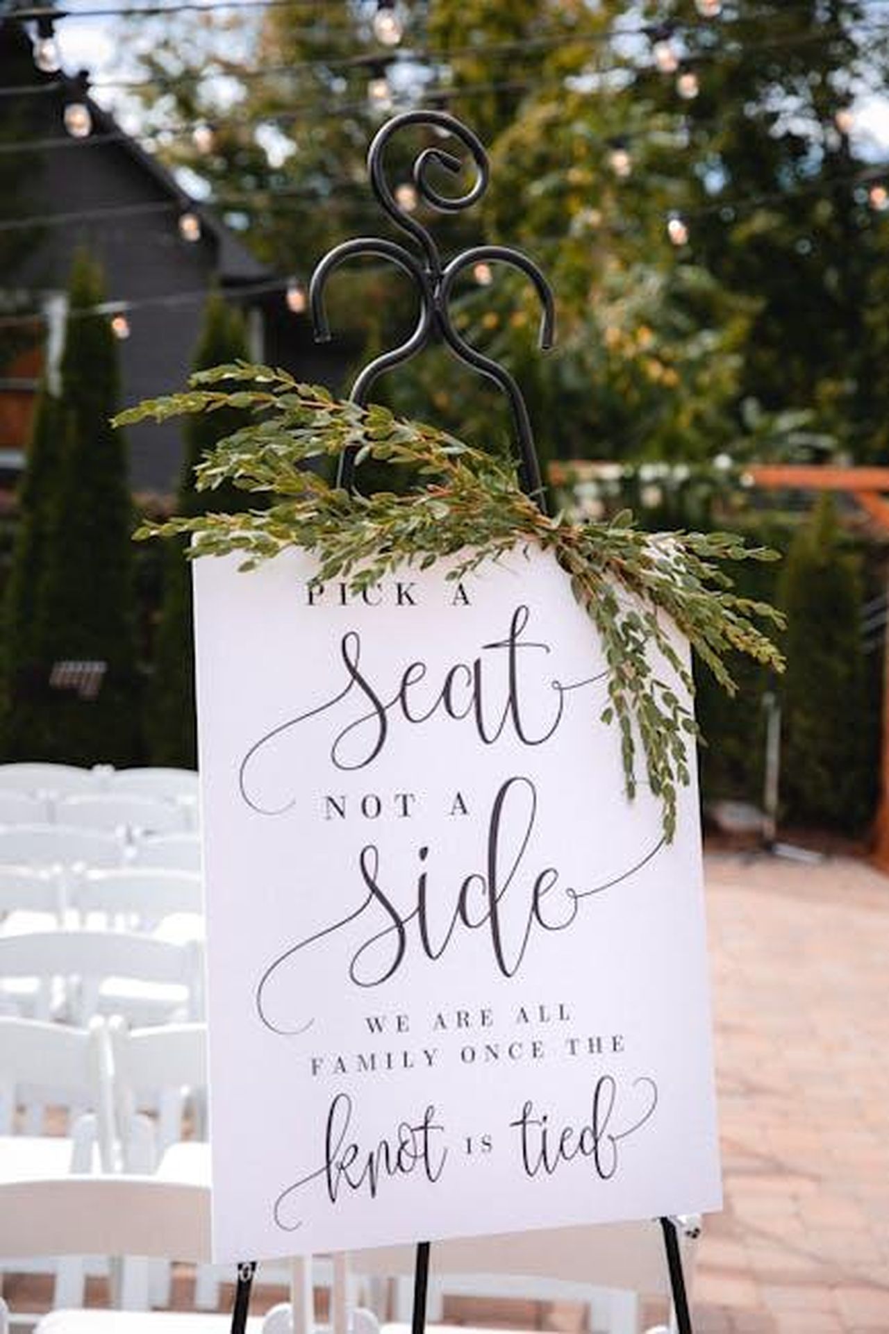 Critiche_allorganizzazione_del_festival_XQ1qAz0PP4 - Confidenze24 Source: Chapin Jones - pexels - Charming wedding sign outdoors urging guests to 'Pick a Seat Not a Side'.