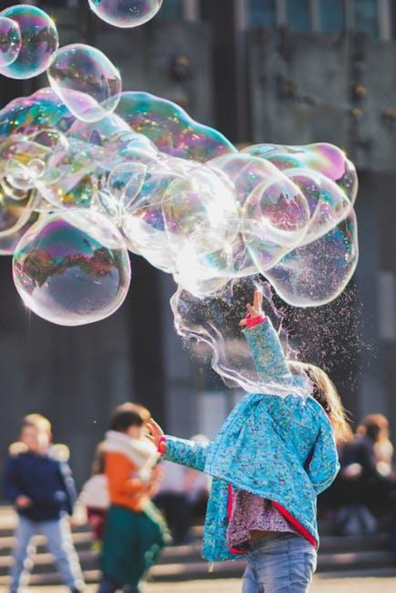Critiche_e_supporto_per_Kate_Cassidy_rA8dsiT5he - Confidenze24 Source: Alexander Dummer - pexels - A child delights in chasing and popping giant bubbles in an outdoor setting.