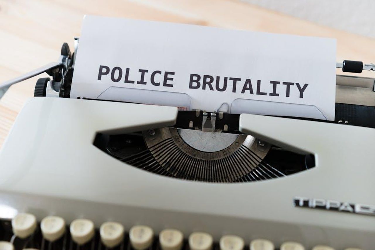 Critiche_per_il_seguito_di_Gwen_sui_social_media_dGnFPpV5Ei - Confidenze24 Source: Markus Winkler - pexels - Close-up of a typewriter with the text 'POLICE BRUTALITY' on paper, highlighting the message of awareness.