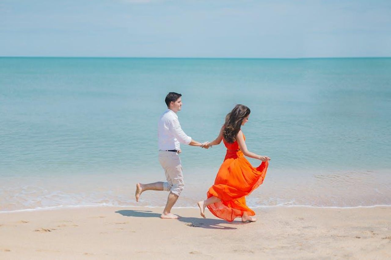 Danny_Jones_e_la_moglie_Georgia_rimarranno_insieme_KpIgSHfEGE - Confidenze24 Source: Anastasiya Lobanovskaya - pexels - A joyful couple runs barefoot along Baku's sunny coastline, embodying carefree summer love.