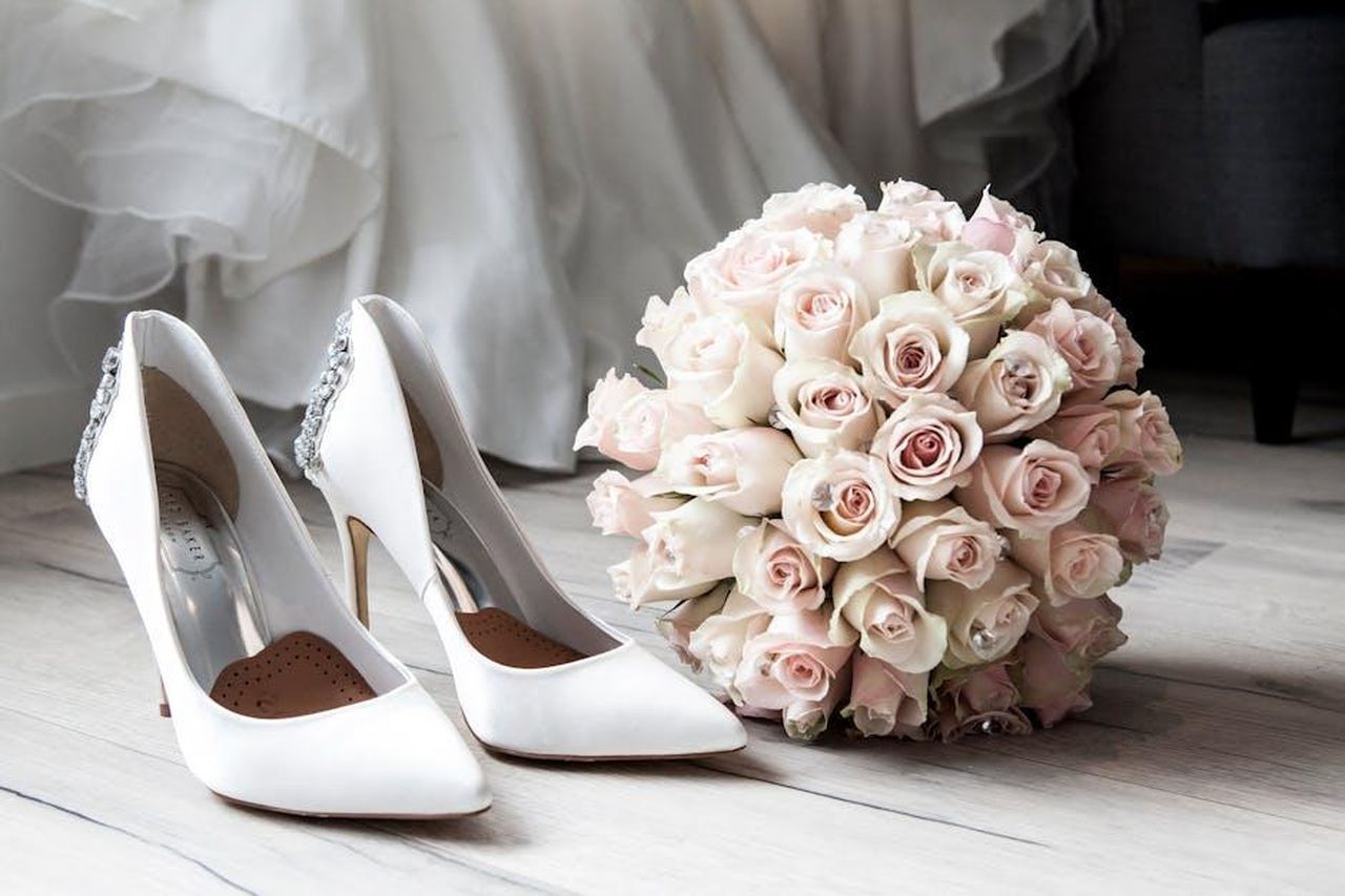Danny_Jones_ha_sposato_la_moglie_Georgia_nel_2014_sdy8liNaiQ - Confidenze24 Source: Terje Sollie - pexels - Elegant bridal shoes and bouquet of roses perfect for wedding inspirations.