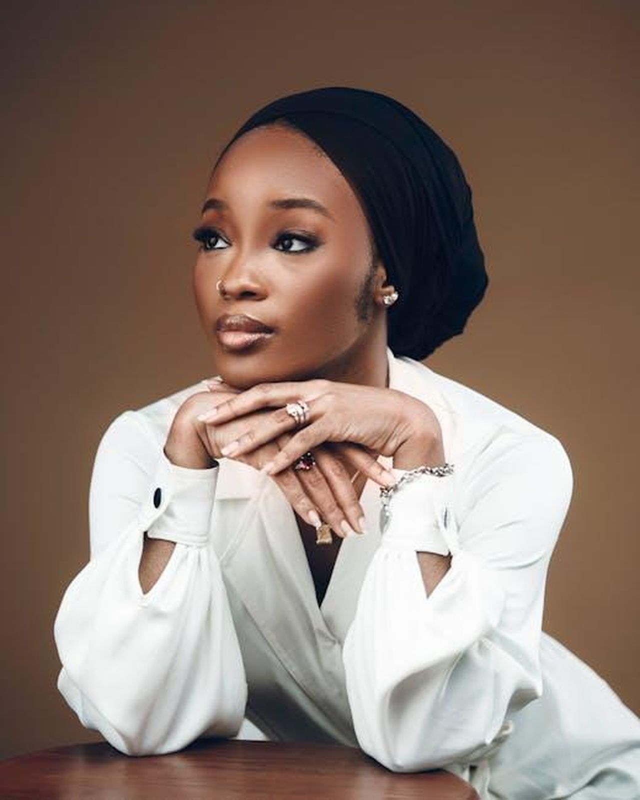 Danny_Jones_rompe_il_silenzio_DgbzNzbDOd - Confidenze24 Source: Darkshade Photos - pexels - Charming portrait of a woman in white with a neutral background, exuding elegance.