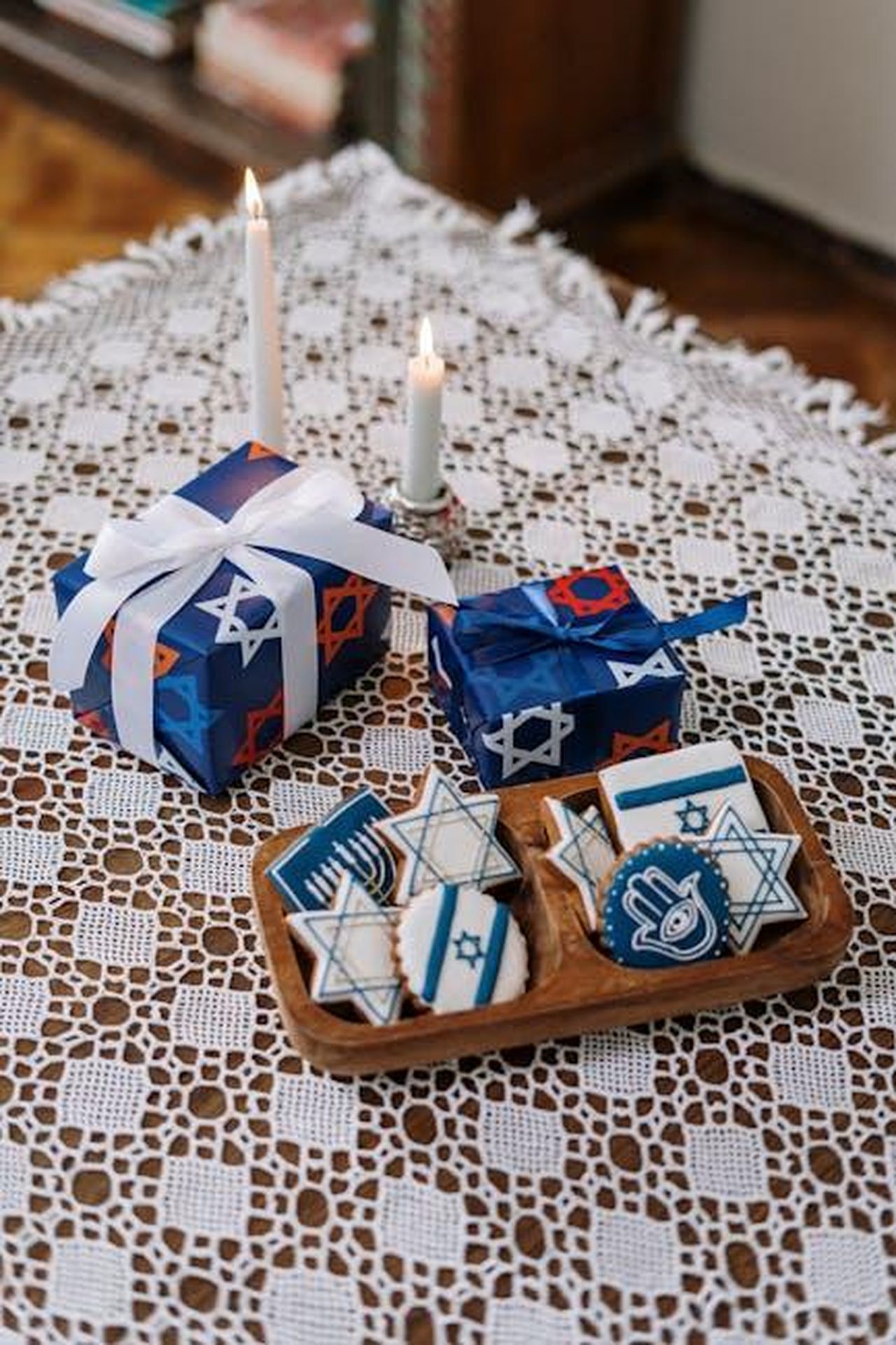 David_non_cambia_outfit_nemmeno_allinterno_gMzO3QlsSN - Confidenze24 Source: cottonbro studio - pexels - Table set with candles, decorated cookies, and gifts with Jewish motifs for a festive celebration.