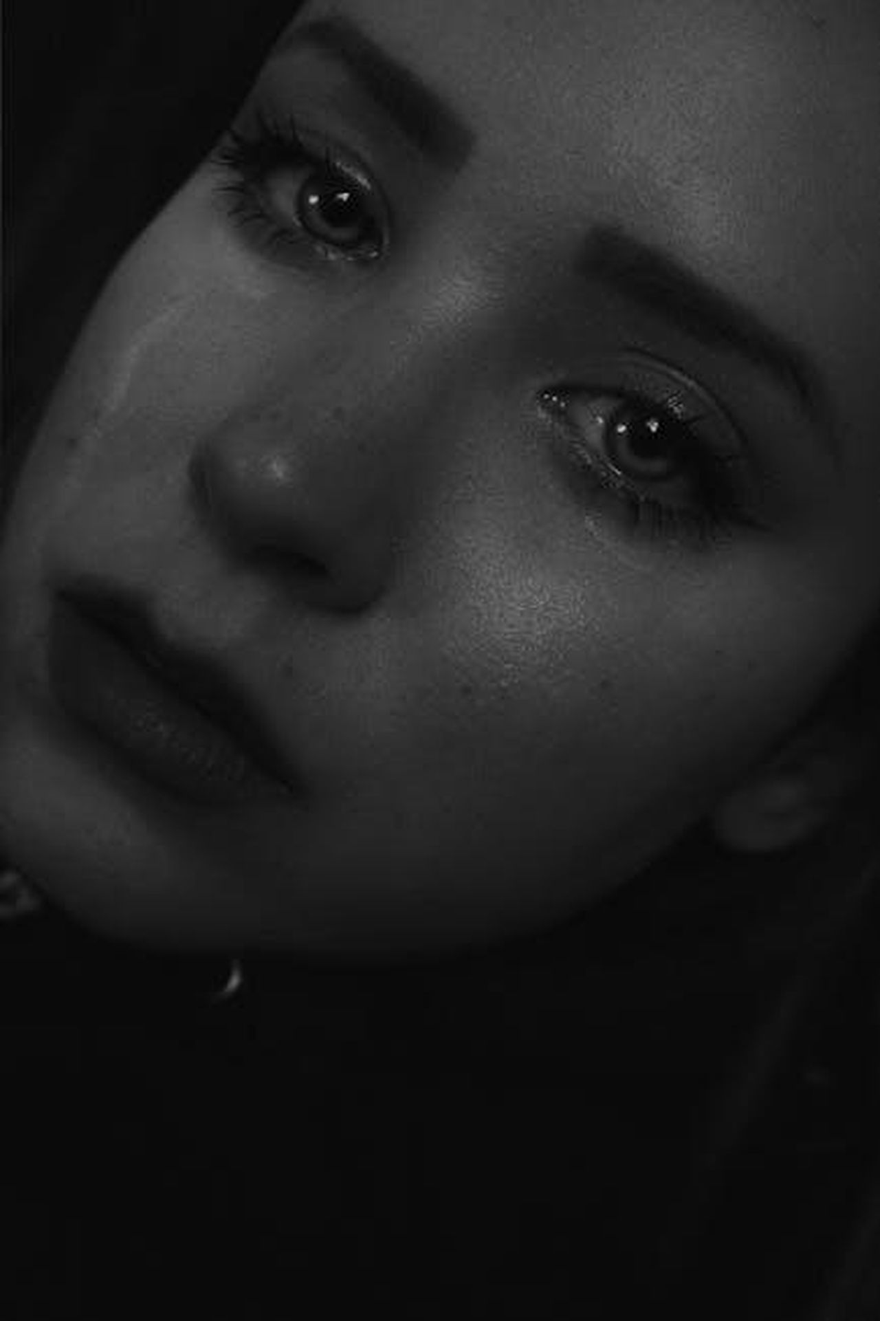 Davvero_infelice_m6S8mWE2Nf - Confidenze24 Source: Bianca Salgado - pexels - A close-up black and white portrait capturing a young woman's tearful expression, showcasing deep emotion and sadness.