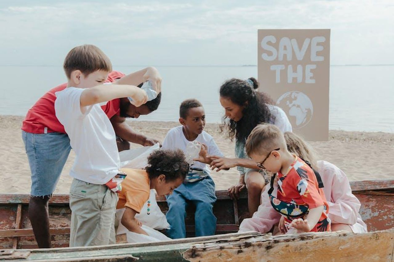 Denuncia_alla_Charity_Commission_86gqKTHHap - Confidenze24 Source: Ron Lach - pexels - A group of children volunteering to clean a beach with a 'Save the Earth' sign.