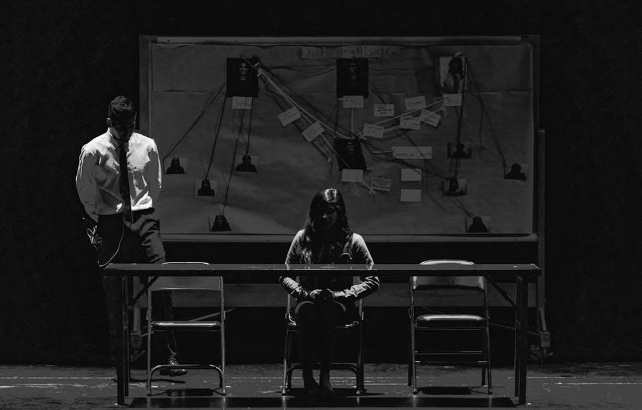 Dettagli_sul_Personaggio_di_Helen_Brock_8wFrArYzPh - Confidenze24 Source: Martin Lopez - pexels - Black and white scene depicting a tense interrogation with suspect and investigator.