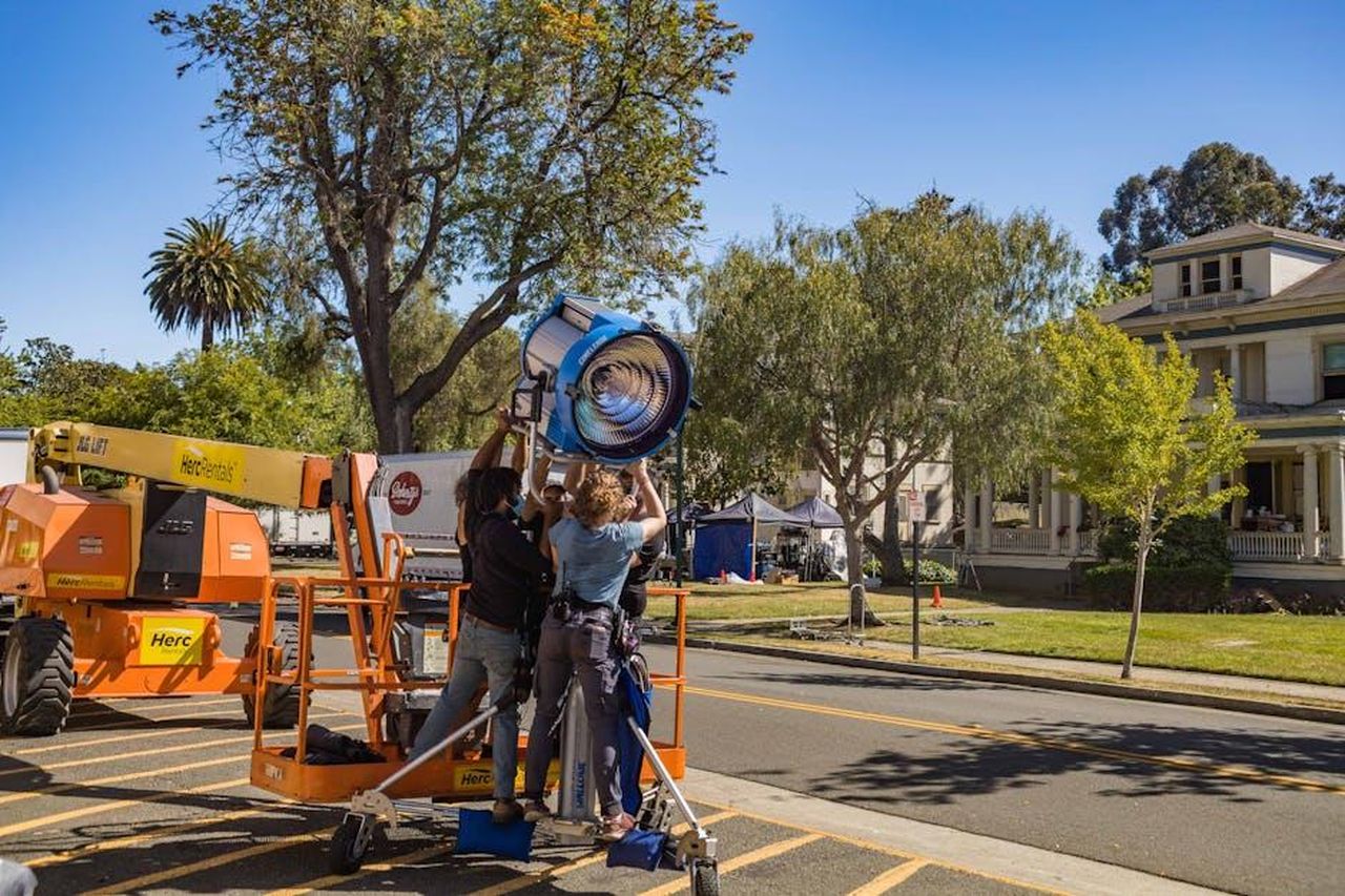 Dettagli_sul_film_e_sul_cast_8hxXOm8c3J - Confidenze24 Source: Robert So - pexels - Film crew setting up lighting equipment outdoors on location shoot.