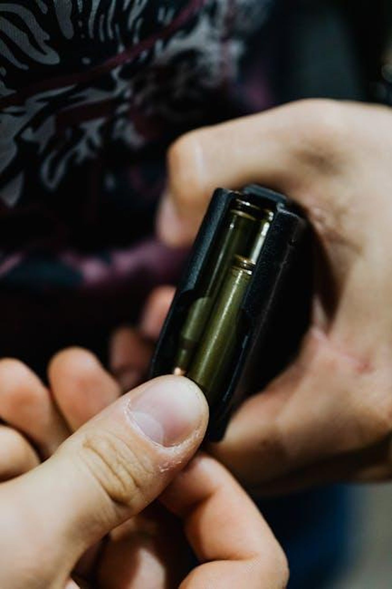 Dettagli_sullEpisodio_Exodus_qROPWZm6BQ - Confidenze24 Source: Photo By: Kaboompics.com - pexels - Detailed close-up of hands loading bullets into a rifle magazine, emphasizing focus and precision.