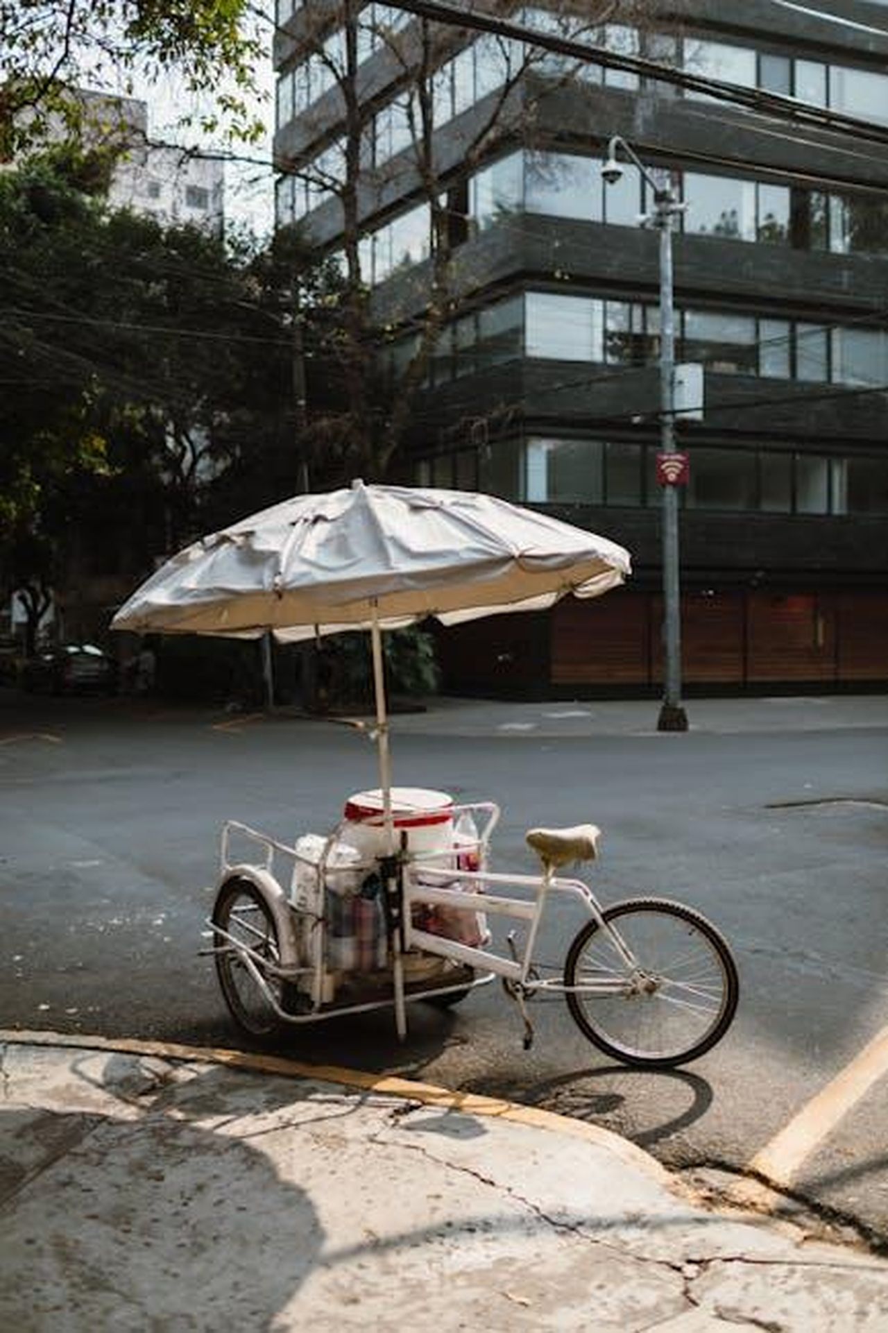 Dettagli_sulla_causa_originale_c3Md4nR9ut - Confidenze24 Source: Tiarra Sorte - pexels - Pedal cart with umbrella on quiet urban street corner, showcasing urban life.