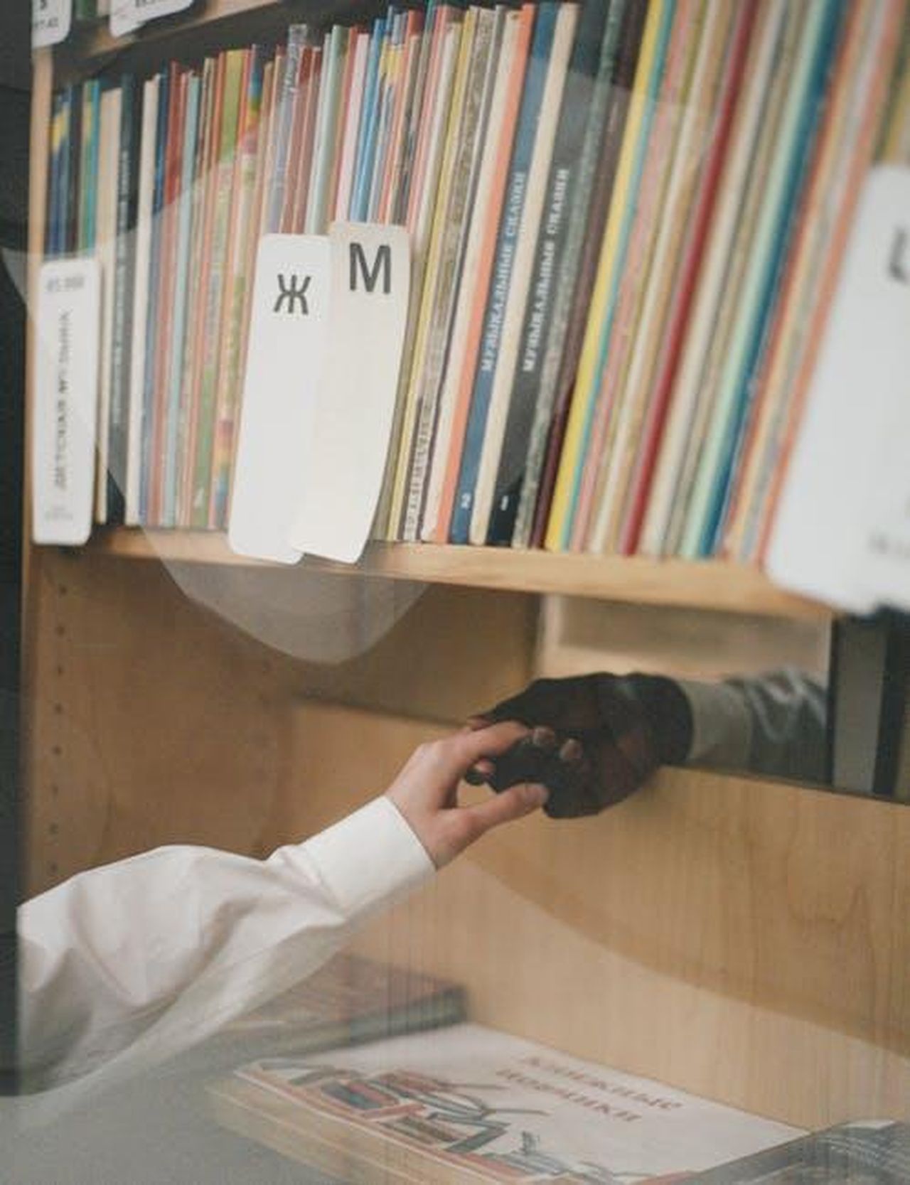 Dettagli_sulla_collezione_Finding_Nemo_TFkf3pCFuR - Confidenze24 Source: Yaroslav Shuraev - pexels - A close-up of hands reaching through bookshelves, creating an intriguing and artistic exploration.
