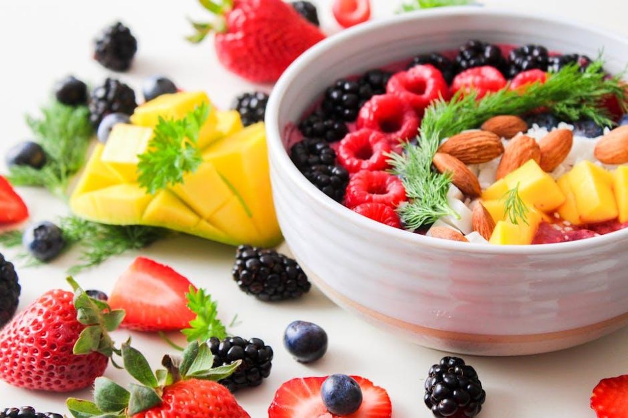 Dettagli_sulla_dieta_vTEGhbywe4 - Confidenze24 Source: Jane T D. - pexels - A vibrant bowl filled with fresh berries, mango, almonds, and herbs, perfect for a healthy snack or breakfast.