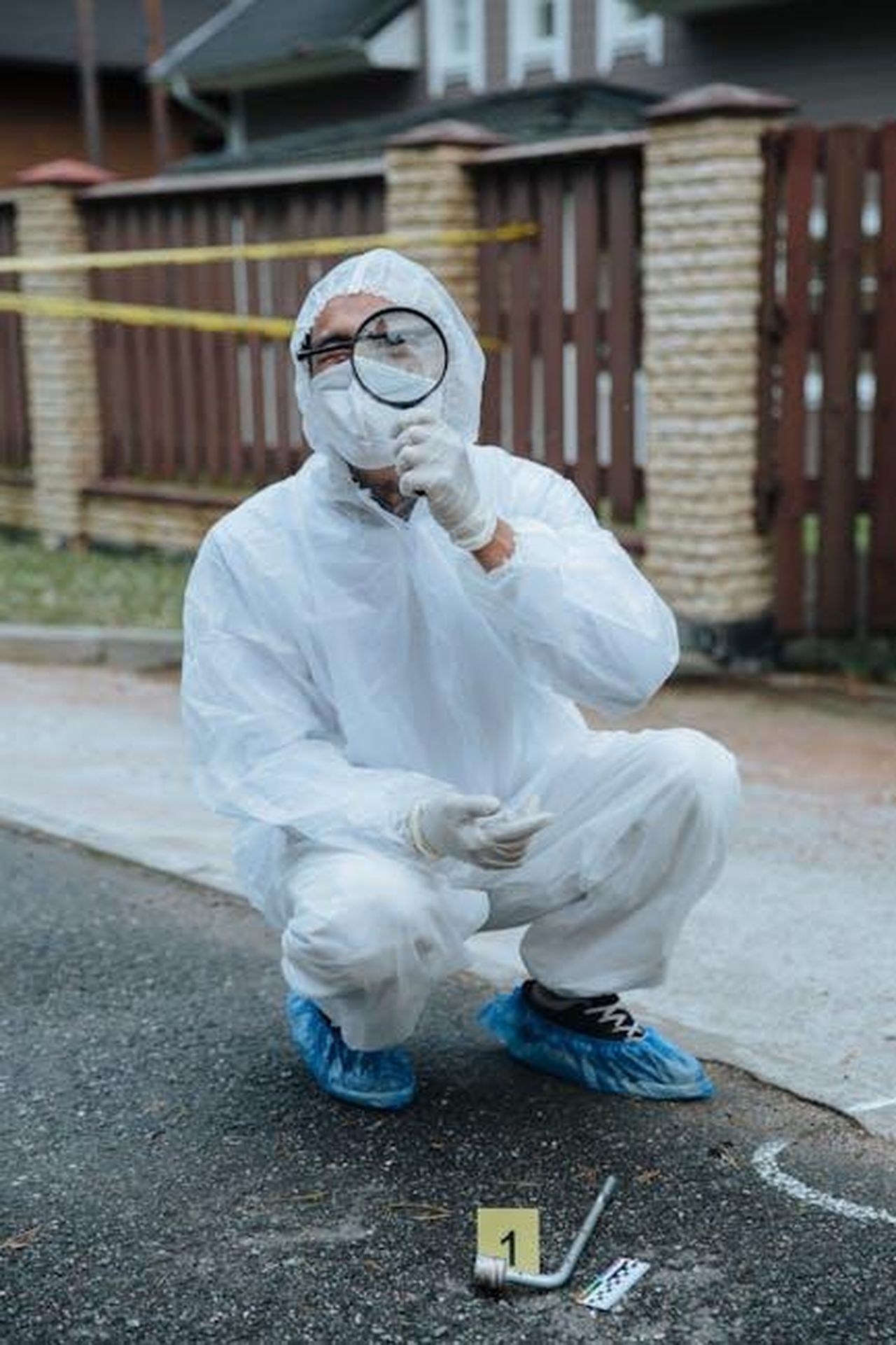 Dettagli_sullomicidio_di_Tyrone_Jones_zG3GxkaqJn - Confidenze24 Source: cottonbro studio - pexels - A forensic investigator in protective gear examines a crime scene with a magnifying glass.