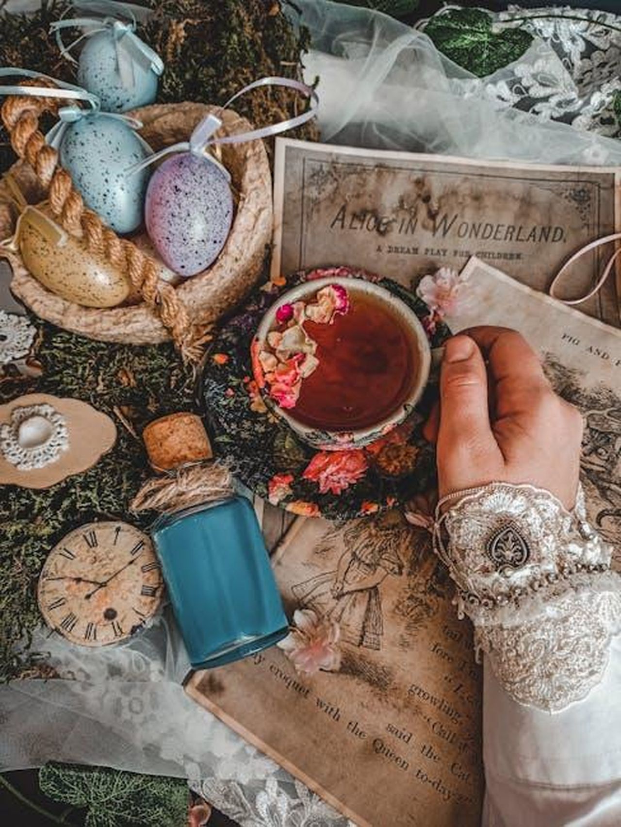 Di_cosa_parler_ACOTAR_6_NrPTk76Swc - Confidenze24 Source: hello aesthe - pexels - A whimsical Alice in Wonderland-inspired tea setup with decorative elements and a cup of tea.