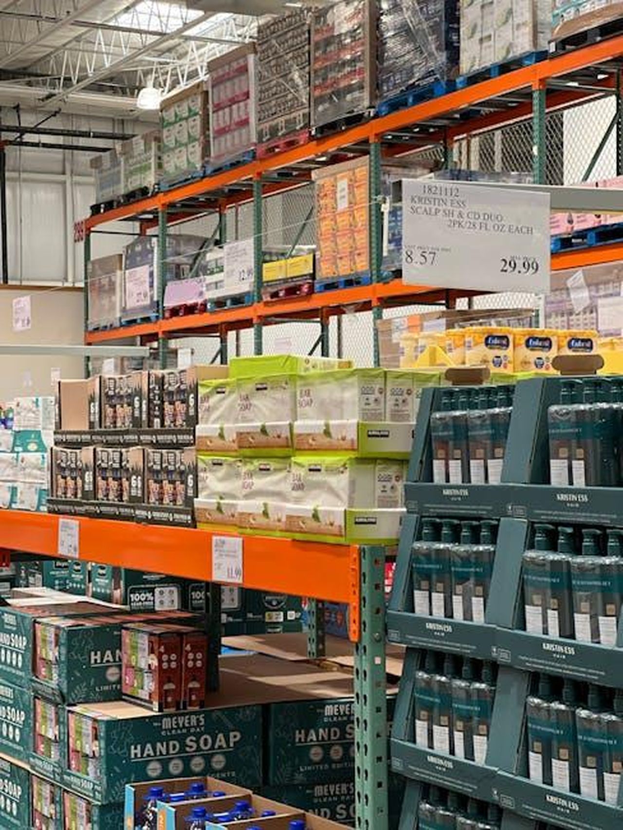 Disponibilit_delle_Hoka_Sneakers_da_Costco_mWSe0OklQy - Confidenze24 Source: Natalia S - pexels - Bulk products displayed on shelves in a wholesale warehouse setting.