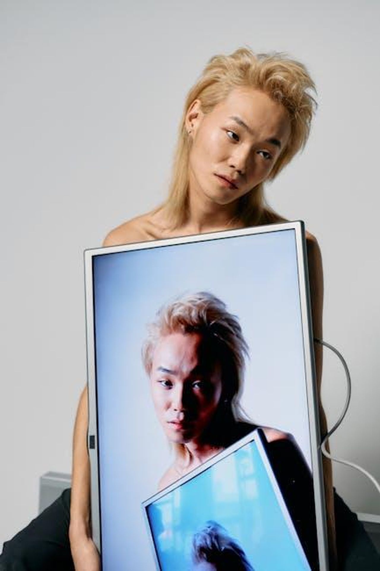 Dolly_Parton_appare_virtualmente_allevento_k3jcjUh0JX - Confidenze24 Source: cottonbro studio - pexels - Fashionable portrait of a model with a monitor in a studio setting, blending human and technology.