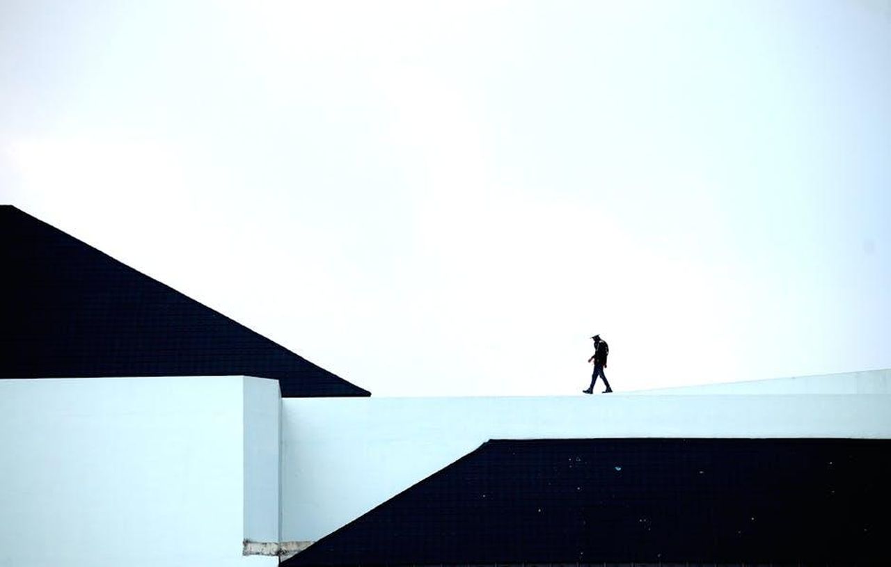 Dove__finita_Kelly_Clarkson_EMJ9gWKzry - Confidenze24 Source: eric anada - pexels - Silhouette of a person walking on a geometric architectural structure under a vast sky.