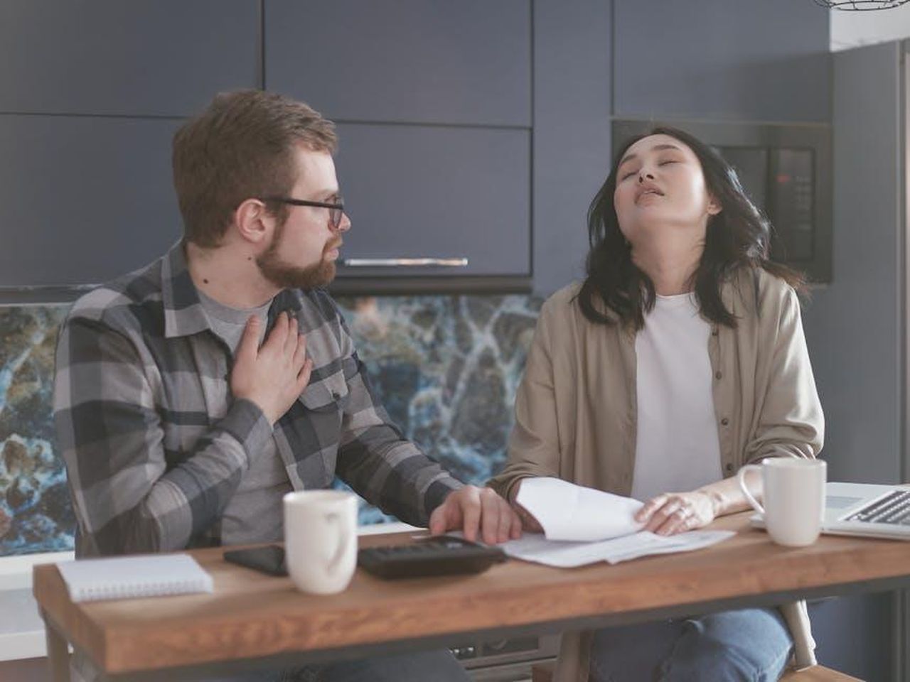 Dove_si_trova_Bobby_secondo_Tracker_J3DIzfBMxQ - Confidenze24 Source: Mikhail Nilov - pexels - A couple experiencing stress while discussing finances in a modern kitchen setting.