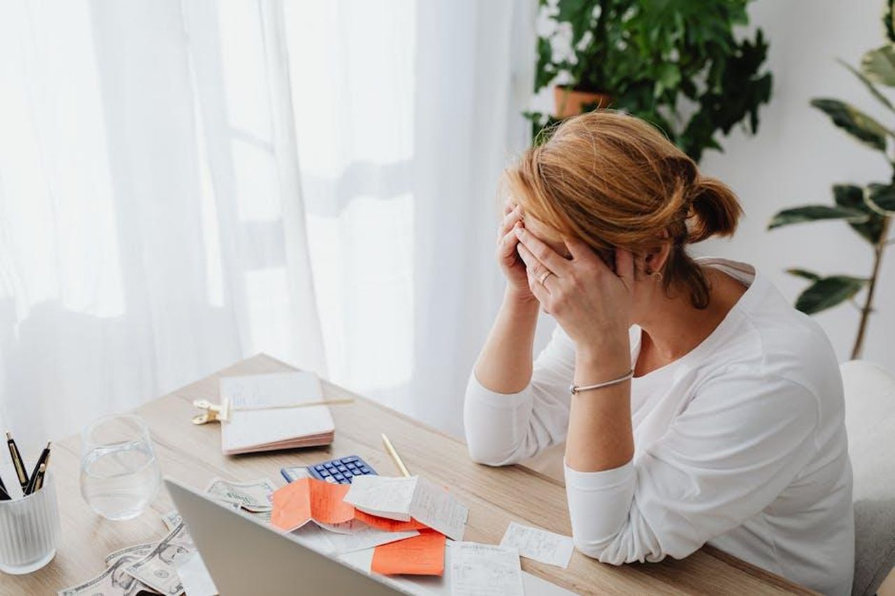 Drew_Sostiene_la_Sua_Versione_e_Chiede_Prove_qrH13Nvx6c - Confidenze24 Source: Photo By: Kaboompics.com - pexels - Woman stressed over financial receipts at a desk, dealing with expenses and calculations.