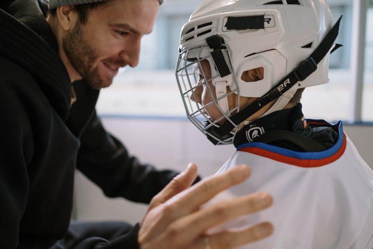 Dwyane_Wade_un_padre_un_amico_e_un_allenatore_5TV7R9O61g - Confidenze24 Source: cottonbro studio - pexels - Father and son bonding moment before an ice hockey game, with the boy in his white jersey and helmet.