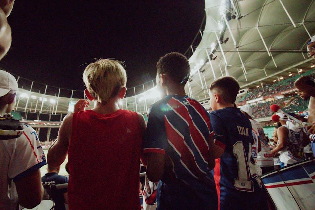 Fan_delusi_sIF6VyE89g - Confidenze24 Source: Priscila Almeida - pexels - Fans cheer from the stands during a night soccer game in a large stadium, full of energy and excitement.