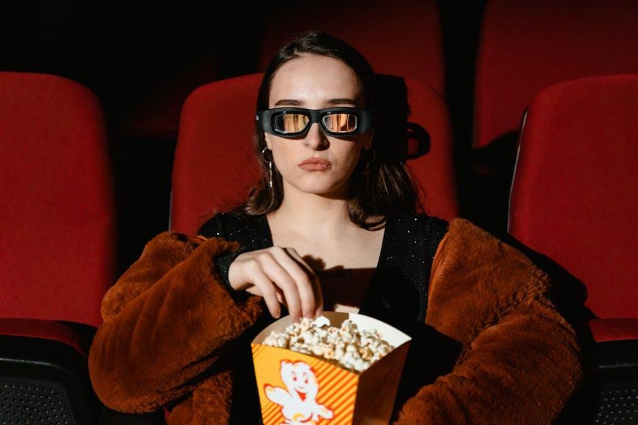 Fate_che_Martin_rallenti_ha_detto_un_telespettatore_4kMK95C2uK - Confidenze24 Source: Tima Miroshnichenko - pexels - A woman in a fur coat enjoying popcorn while watching a 3D movie in a cinema.