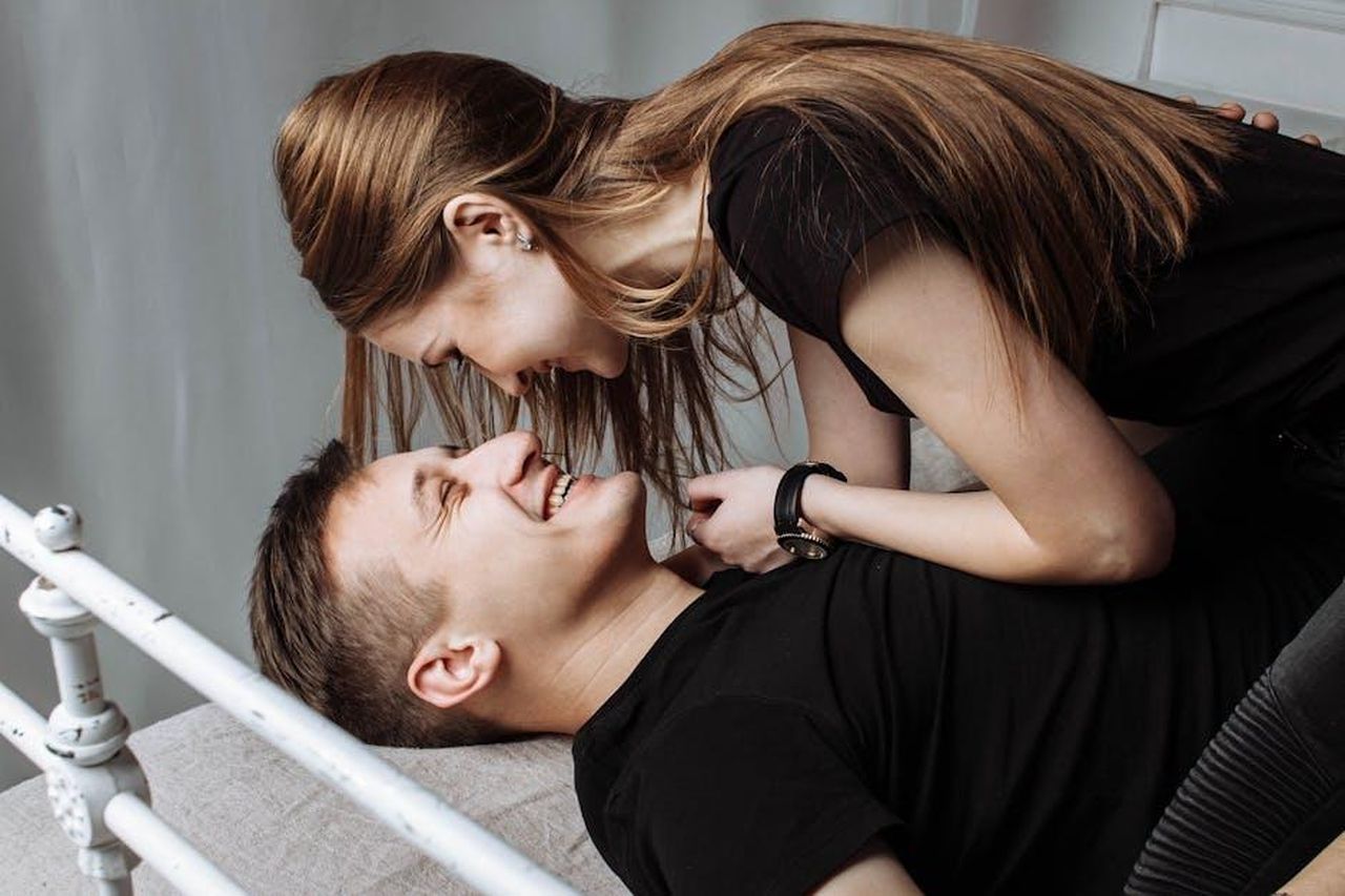 Flirto_con_chiunque_uc8P7bW7ng - Confidenze24 Source: Pixabay - pexels - A joyful young couple enjoying intimate moments and laughter on a bed indoors.