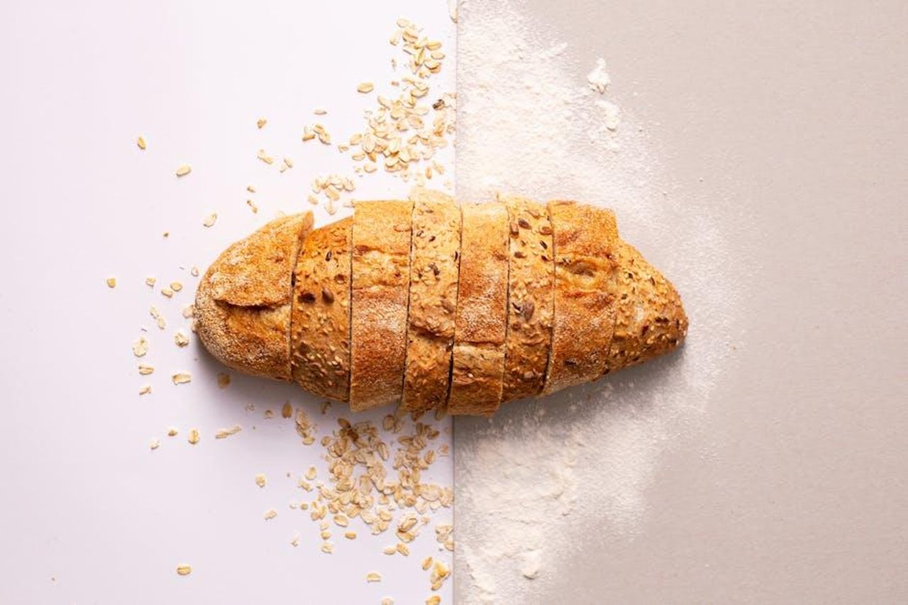 Fruity_Oat_Squares_v6yvwBe1aj - Confidenze24 Source: Mariana Kurnyk - pexels - Freshly sliced whole grain bread with oats and flour provides a rustic and nutritious appeal.
