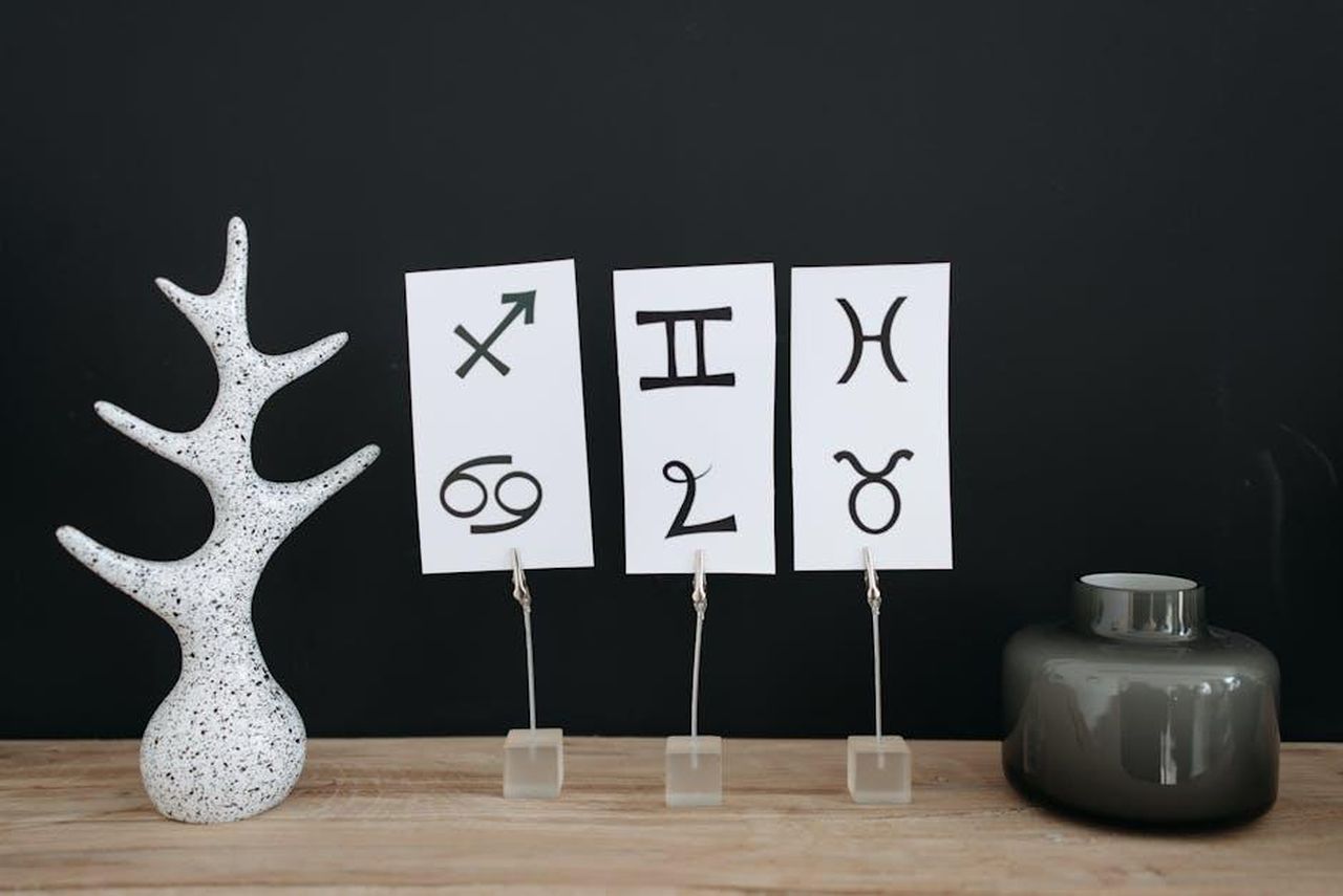 Gemelli_21_maggio__21_giugno_IiOWkx44fh - Confidenze24 Source: Pavel Danilyuk - pexels - Minimalist decor showcasing zodiac signs with modern elements on a wooden table.