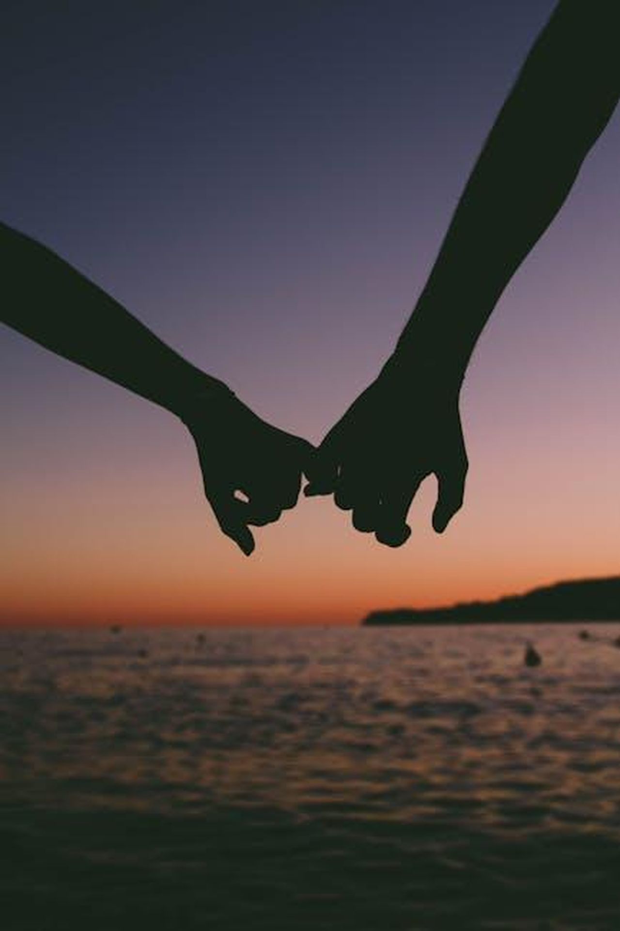 Georgia_Toffolo_e_James_KYpAl67zgh - Confidenze24 Source: Valentin Antonucci - pexels - Silhouetted hands holding at sunset over a calm ocean. Romantic and peaceful seascape.