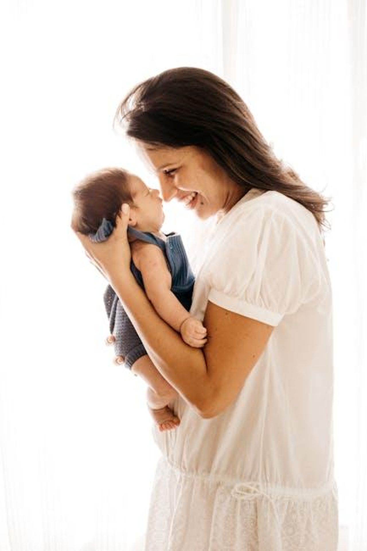 Georgina_Chapman_parla_della_maternit_e_del_suo_cambiamento_vmdGHbIEeE - Confidenze24 Source: Jonathan Borba - pexels - A joyful mother cradles her infant closely, expressing love and happiness.