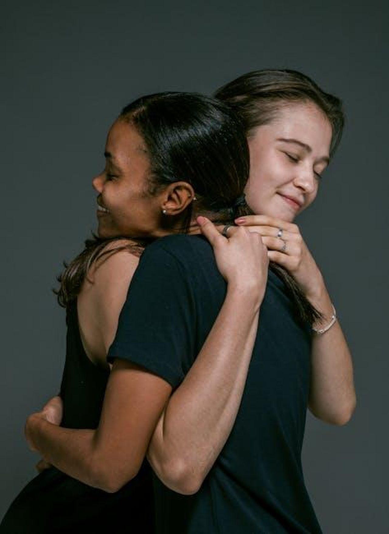Gino_DAcampo_news__Paul_Young_ha_perdonato_lo_chef_hAHfO2Olbi - Confidenze24 Source: Ketut Subiyanto - pexels - Two women of different ethnicities share a warm hug, symbolizing love and friendship against a gray backdrop.