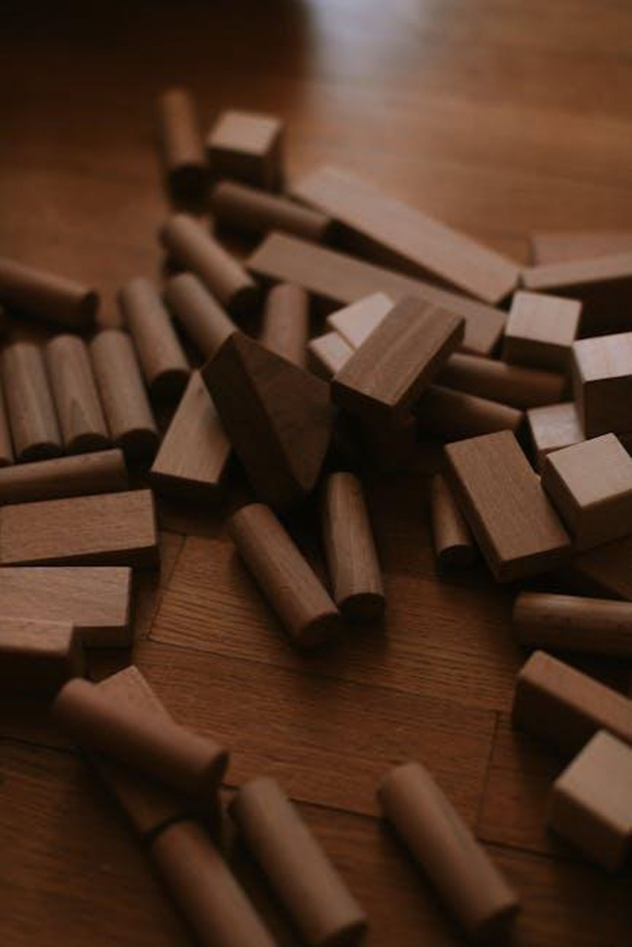 Giocattoli_che_stimolano_la_creativit_0GPSdc75ik - Confidenze24 Source: Julia Bataeva - pexels - A pile of natural wooden building blocks scattered on a wooden floor.