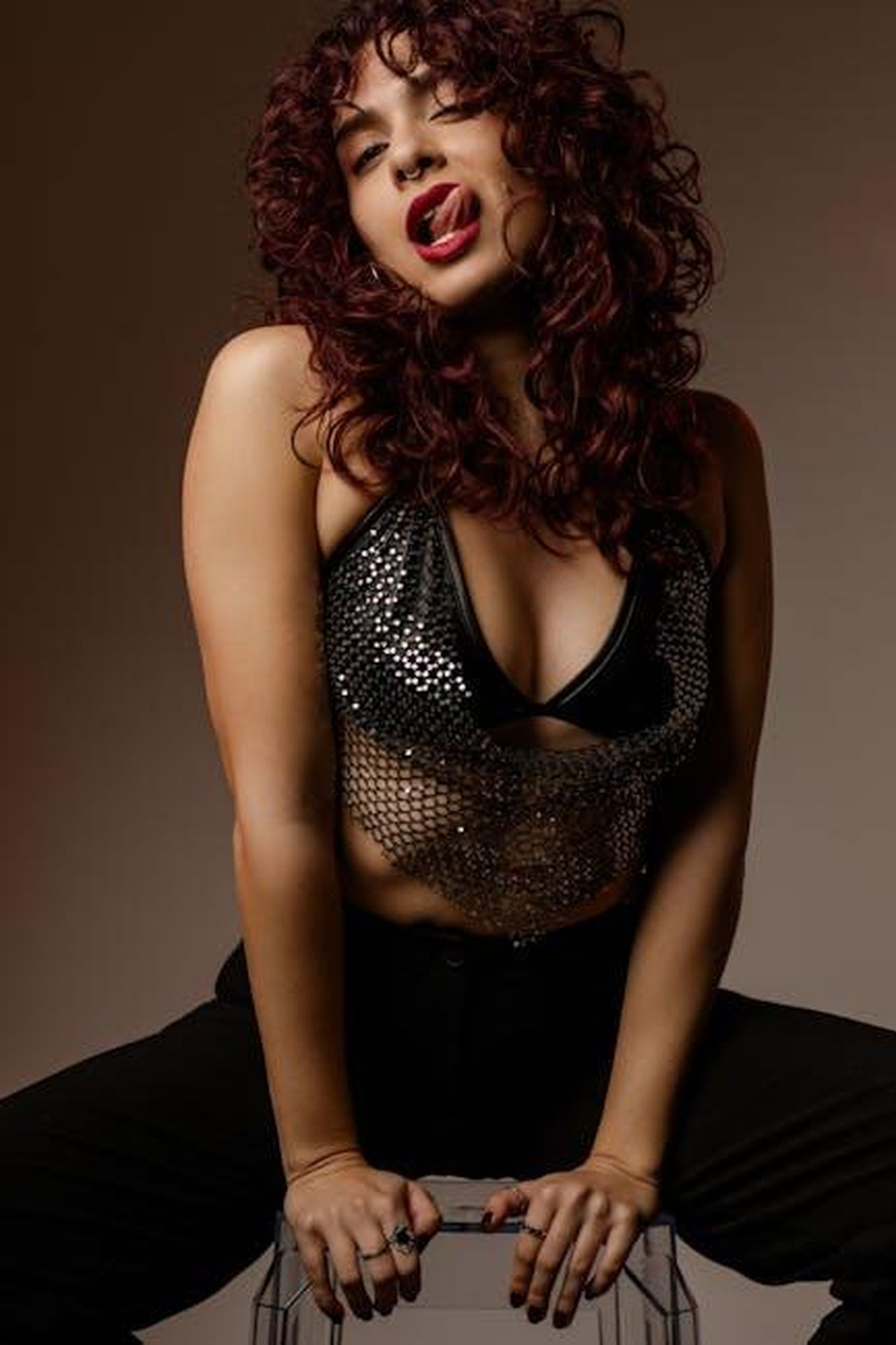 Gioielli_adorabili_della_collezione_Disney_x_Kate_Spade_6R9ZMK8jDz - Confidenze24 Source: Lazarus Ziridis - pexels - Confident woman with curly hair poses boldly in studio lighting.