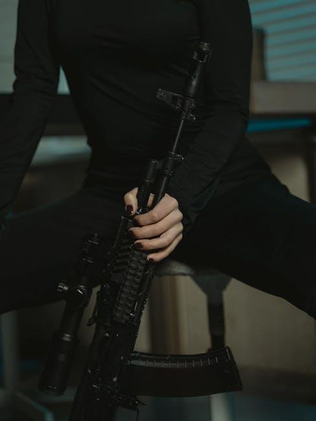 Gli_alti_e_bassi_di_SWAT_nel_corso_degli_anni_SR8ZgQt6dr - Confidenze24 Source: Tima Miroshnichenko - pexels - Mysterious person in black holding a rifle. Indoor setting with a moody atmosphere.