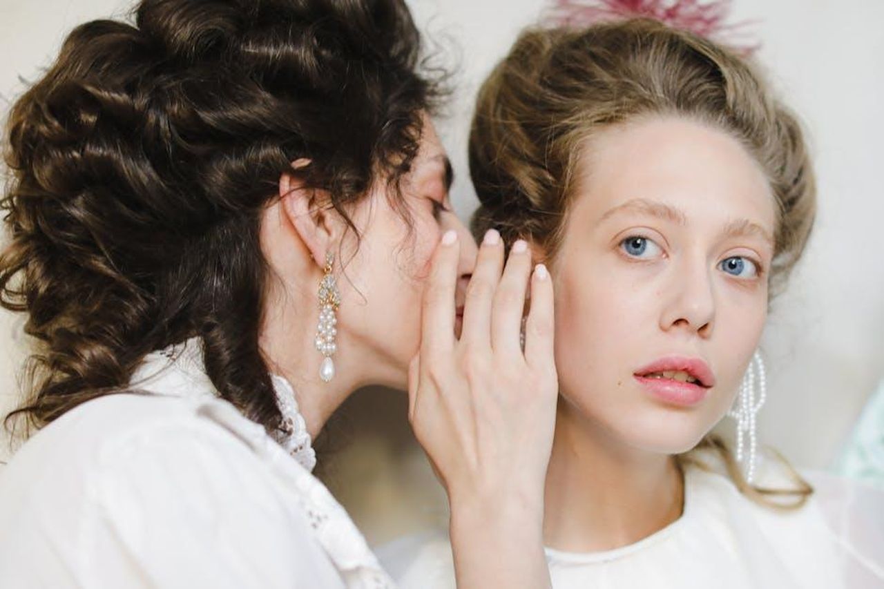 Gossip_e_polemiche_tra_celebrit_GFsaMJRgJE - Confidenze24 Source: cottonbro studio - pexels - Two women dressed in 19th century fashion share a secret, showcasing elegance and friendship.