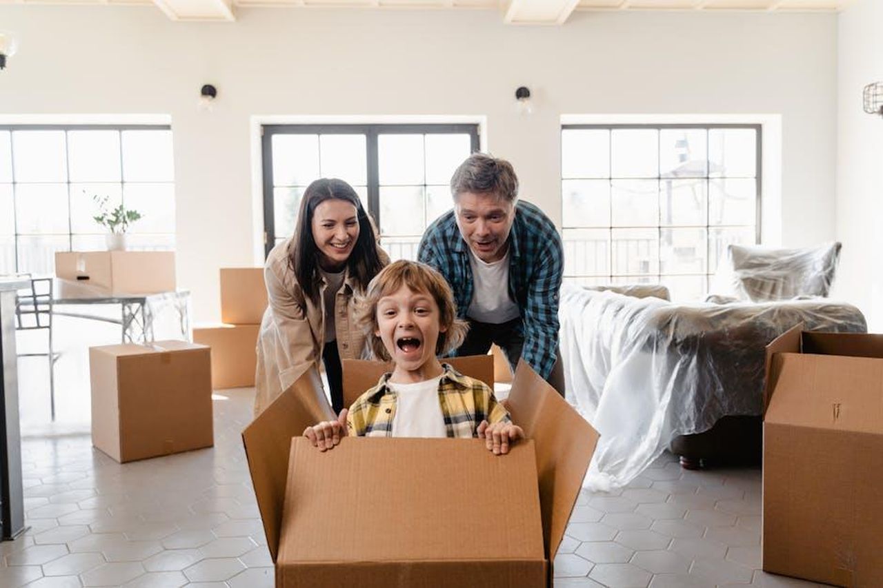 Gwyneth_come_pioniera_dello_stile_di_vita_9TR8hncksv - Confidenze24 Source: MART PRODUCTION - pexels - Family playing with cardboard boxes during move into a new home, symbolizing joy and togetherness.