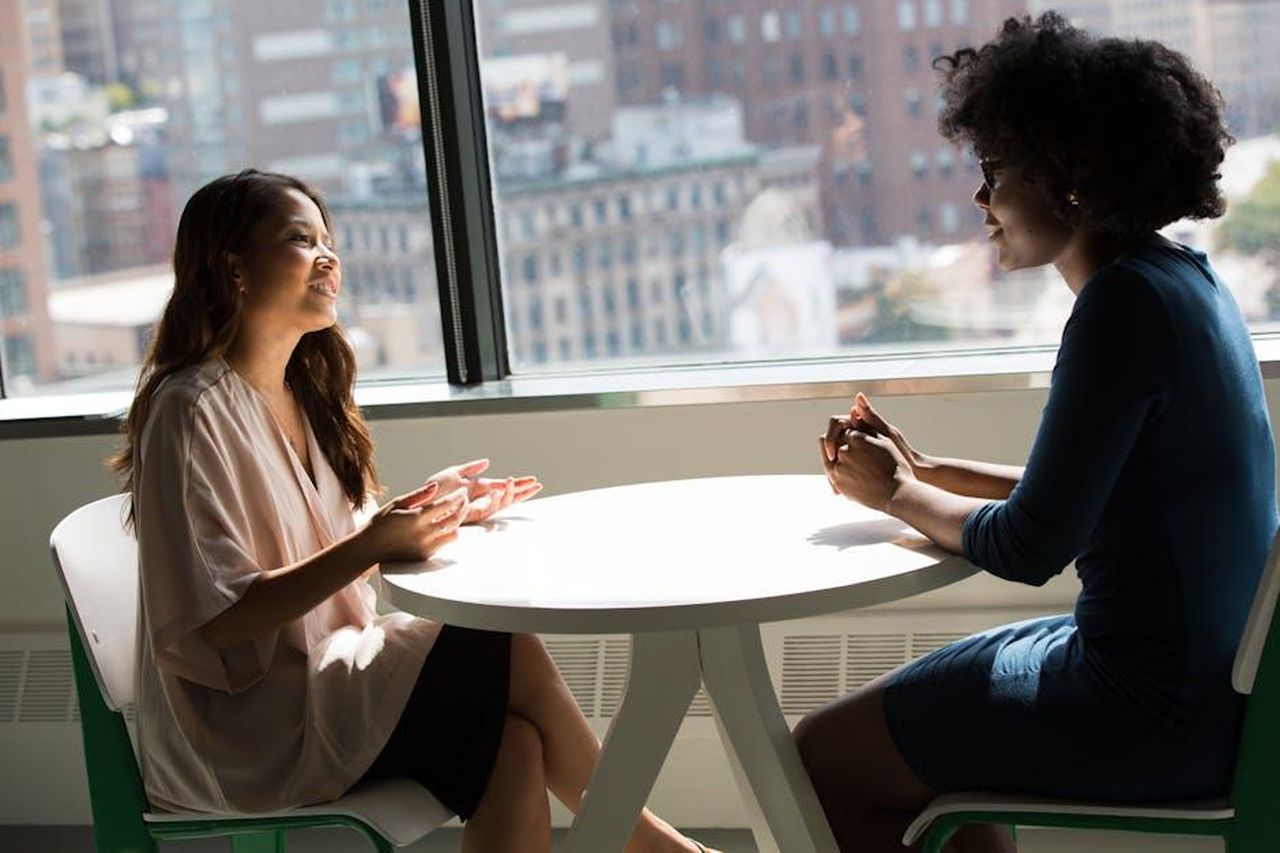 Ha_sempre_supportato_Dolly_4bFNwDgklr - Confidenze24 Source: Christina Morillo - pexels - Two professional women having a discussion at a desk in a bright office setting.