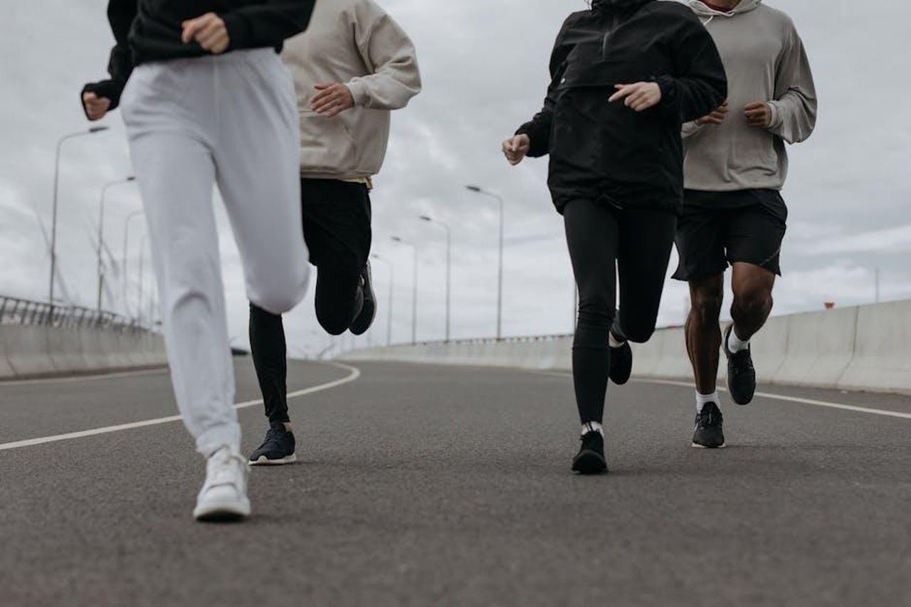 Ho_sentito_subito_Alison_e_Holly_H2DtkbcJRx - Confidenze24 Source: cottonbro studio - pexels - Four people jogging together on an urban road, showcasing fitness and teamwork.