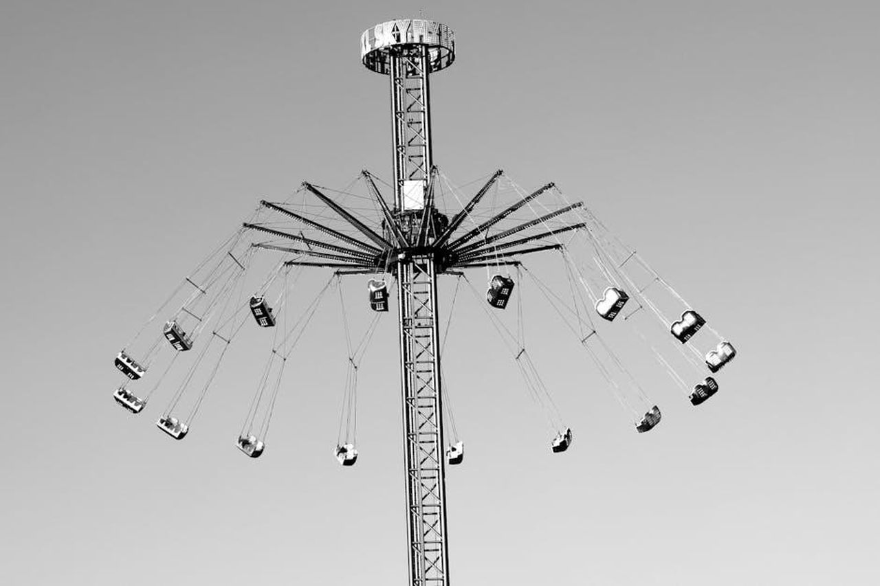 Hope_e_lex_marito_Chase_McWhorter_coinvolti_nello_scandalo_del_swinging_8LEhsiBlLp - Confidenze24 Source: deep Bhullar - pexels - A black and white image of an aerial swing ride against a clear sky, capturing motion.