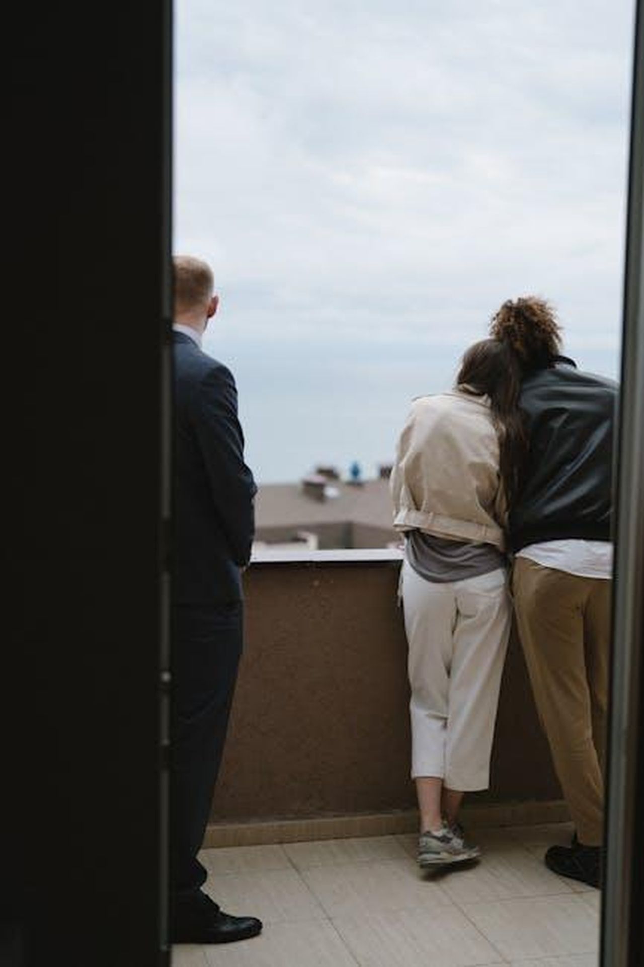 Hubbard_e_Kufe_stanno_cercando_un_appartamento_G9aB6mNEwS - Confidenze24 Source: Anastasia Shuraeva - pexels - Couple leaning on balcony with realtor viewing new home landscape.