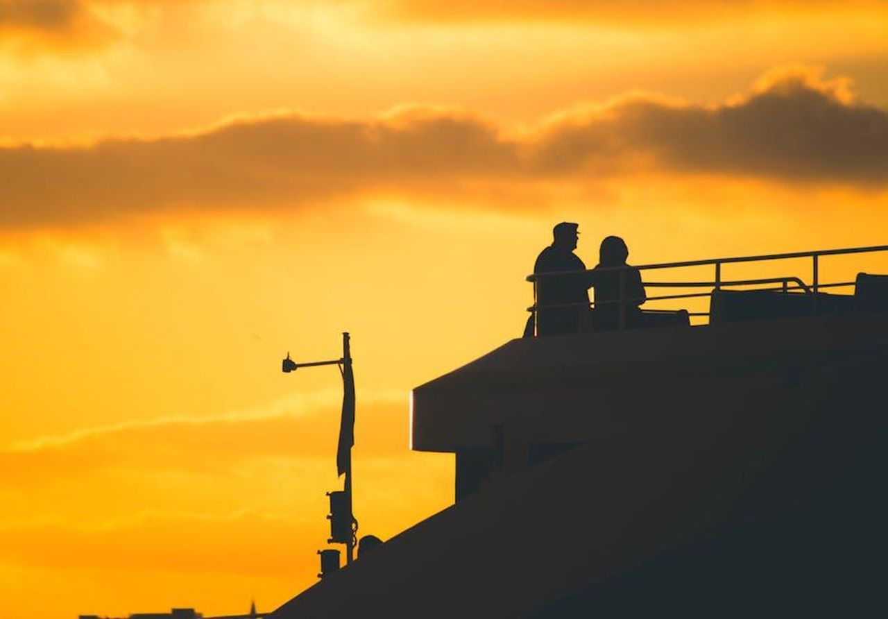 Hugh_Jackman_e_Sutton_Foster_Confermano_la_Loro_Relazione_BSGXDmQHpW - Confidenze24 Source: Serdar Göksu - pexels - Silhouetted couple enjoying a rooftop view at sunset, with golden skies and calming atmosphere.