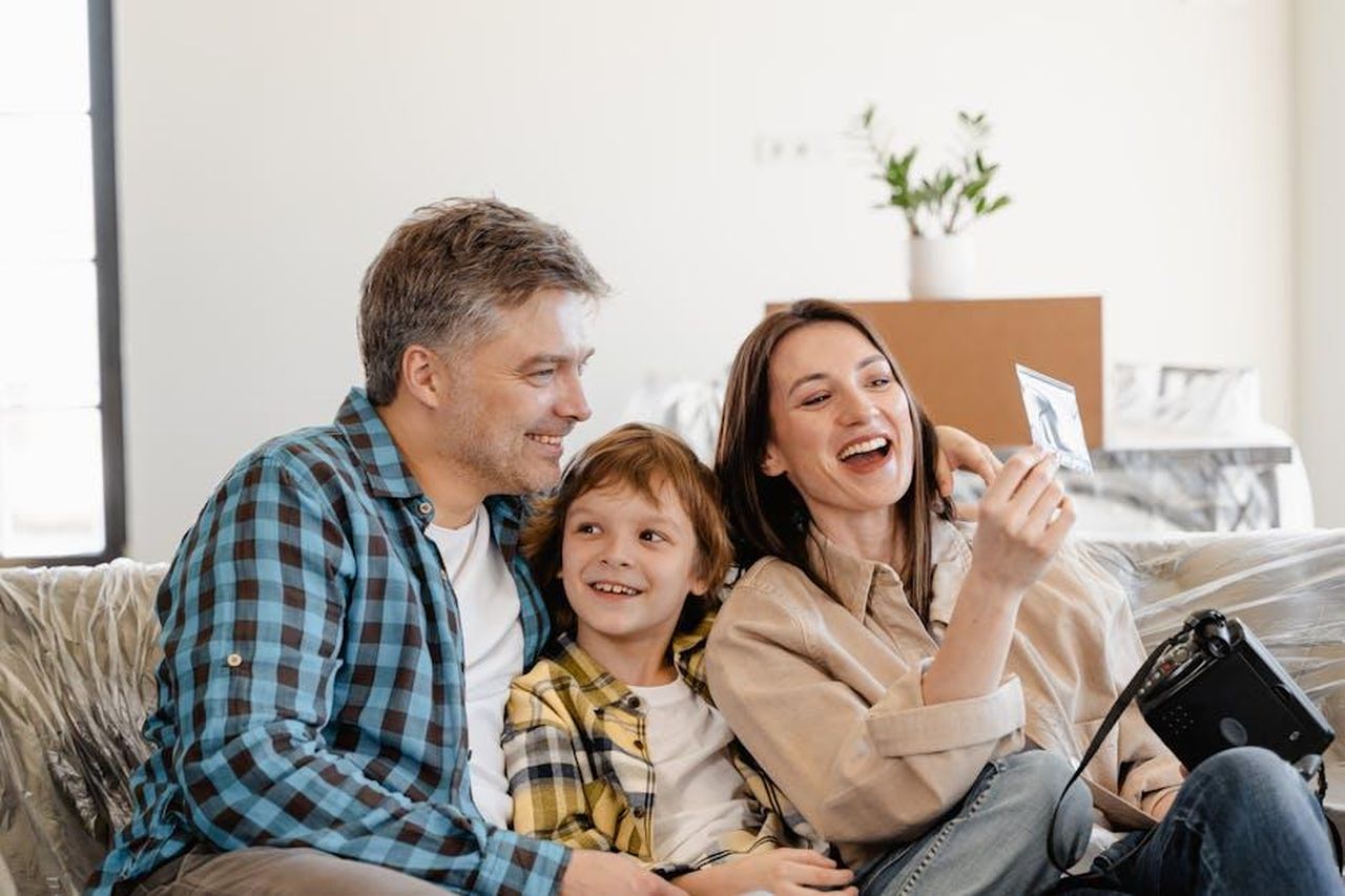 I_Biebers_stanno_considerando_di_trasferirsi_aTVRHerWQE - Confidenze24 Source: MART PRODUCTION - pexels - A cheerful family enjoys time together on a couch surrounded by moving boxes in their new home.