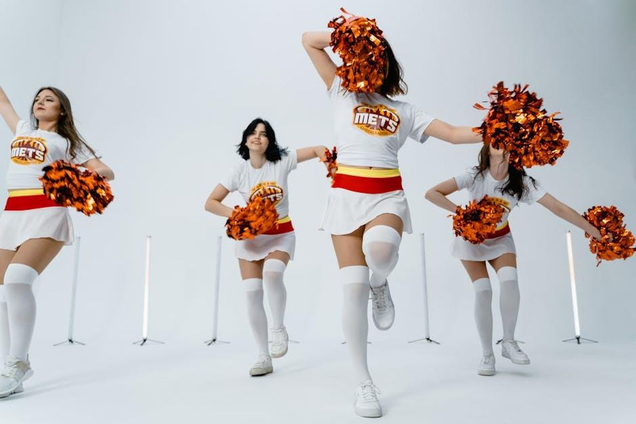I_Fan_Mostrano_Supporto_per_Billy_Joel_Durante_le_Sue_Difficolt_2mScCE98JF - Confidenze24 Source: MART PRODUCTION - pexels - Dynamic group of cheerleaders performing with pom poms in a studio setting.
