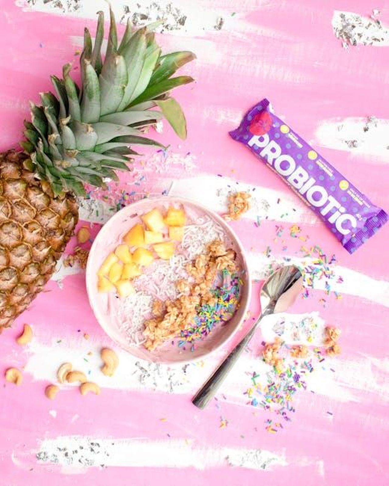 I_Probiotici_Sono_Benefici_e_Possono_Essere_Gustosi_VhlnTAip93 - Confidenze24 Source: Karley Kosmos - pexels - Colorful smoothie bowl with fresh pineapple, probiotics, and sprinkles on a pink background.