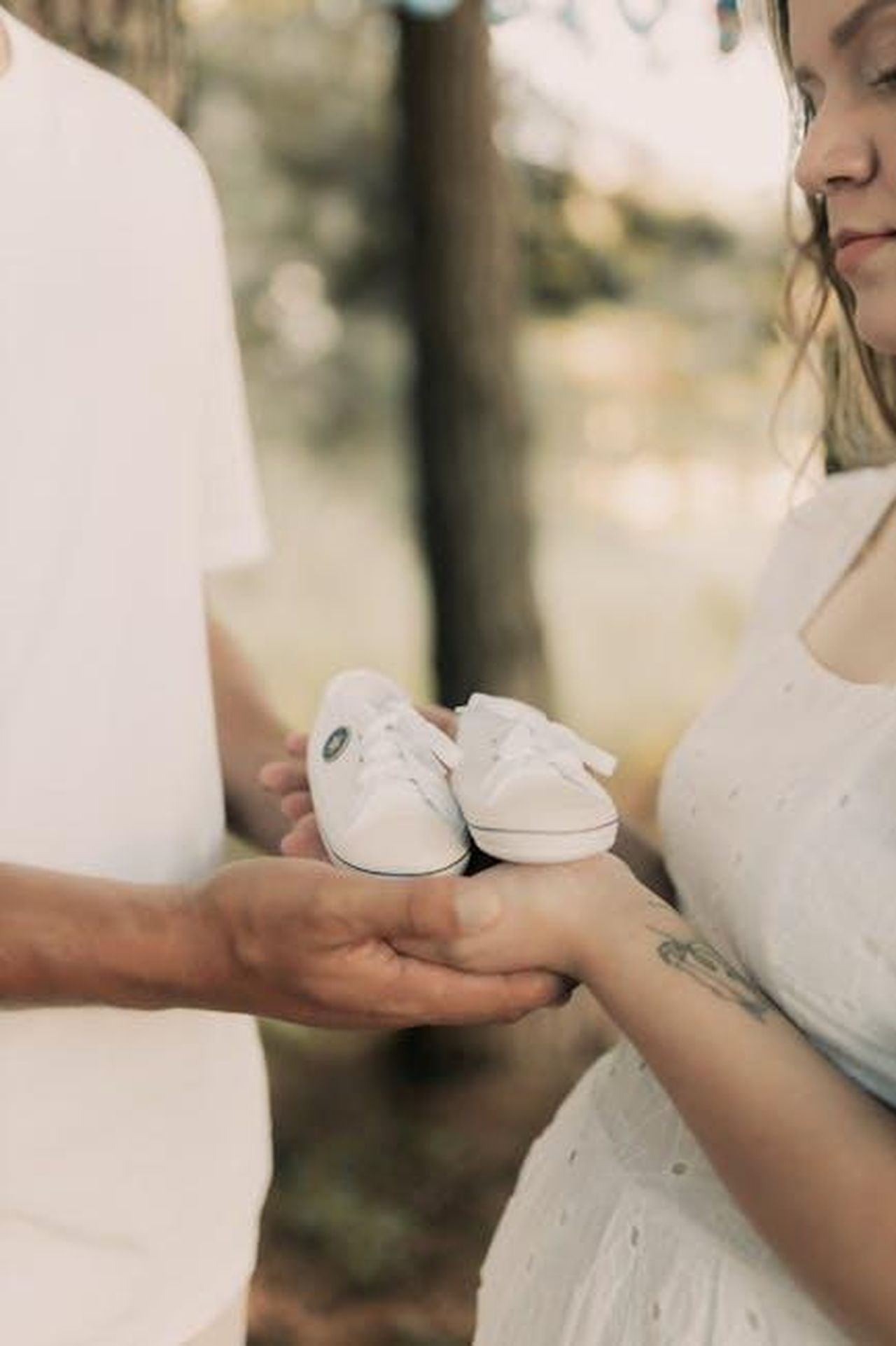 I_figli_di_Gabby_vicini_alle_lacrime_cuUO3IoPU7 - Confidenze24 Source: Alexander Mass - pexels - Expecting couple holding baby shoes in anticipation outdoors.