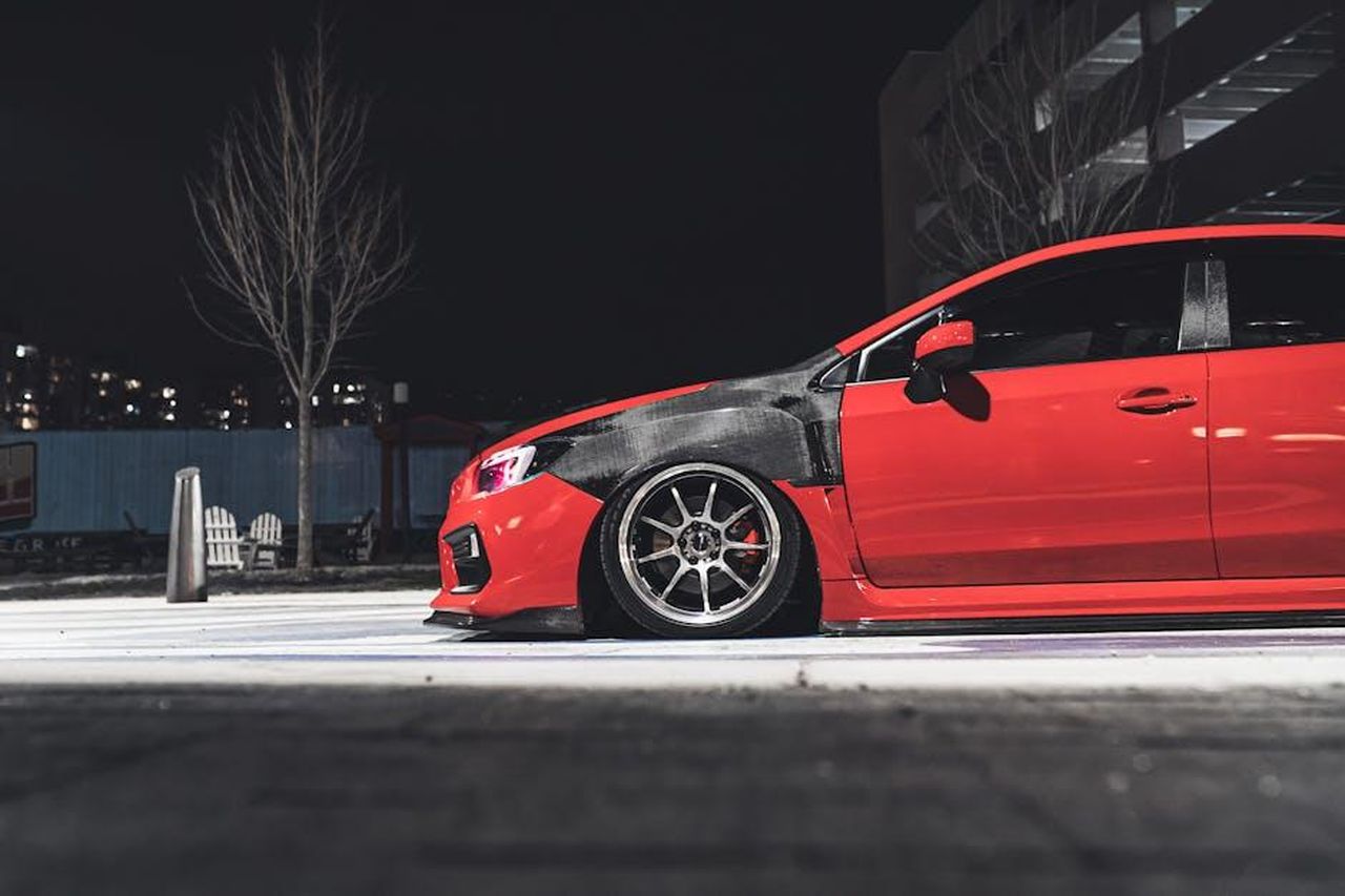 I_figli_di_Michael_Jackson_Bigi_mantiene_un_profilo_basso_c4Cgr3iwZG - Confidenze24 Source: Garvin St. Villier - pexels - A sleek red sports coupe car parked on an urban street at night.
