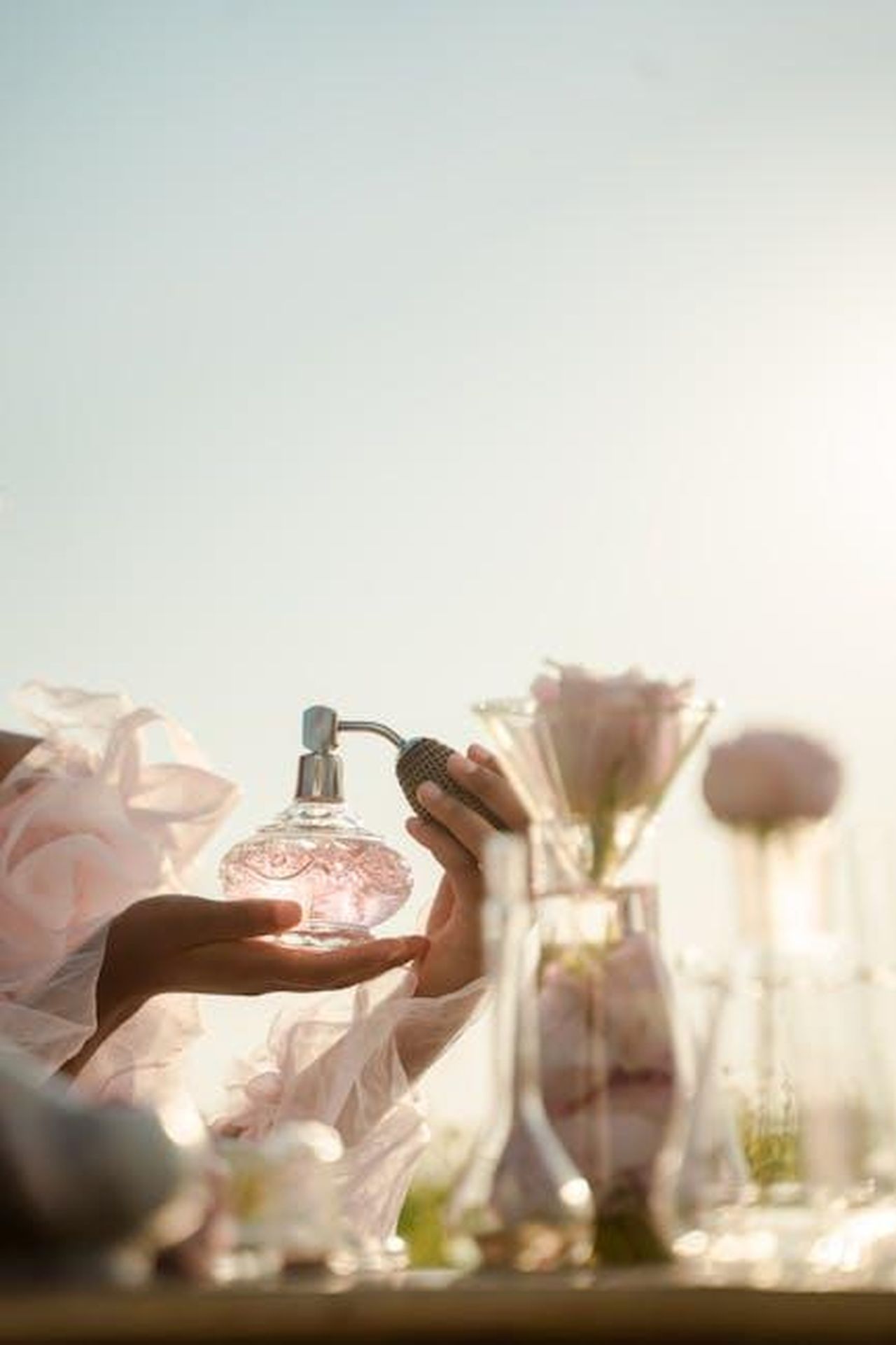 I_migliori_profumi_in_saldo_da_Nordstrom_per_la_primavera_2025_Inmvergq5V - Confidenze24 Source: Ron Lach - pexels - A delicate perfume bottle is held with a floral arrangement in soft daylight.