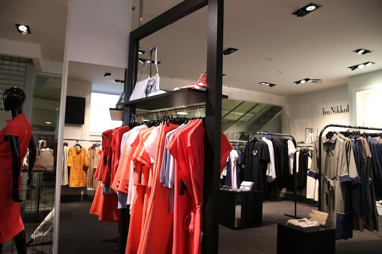I_migliori_stili_in_saldo_abbigliamento_e_accessori_9YFyqeTHsc - Confidenze24 Source: Edgars Kisuro - pexels - Discover a chic fashion boutique showcasing a variety of colorful clothes on elegant racks.